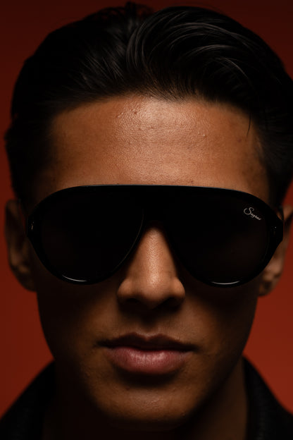 Emiliano wearing regent sunglasses against original red background